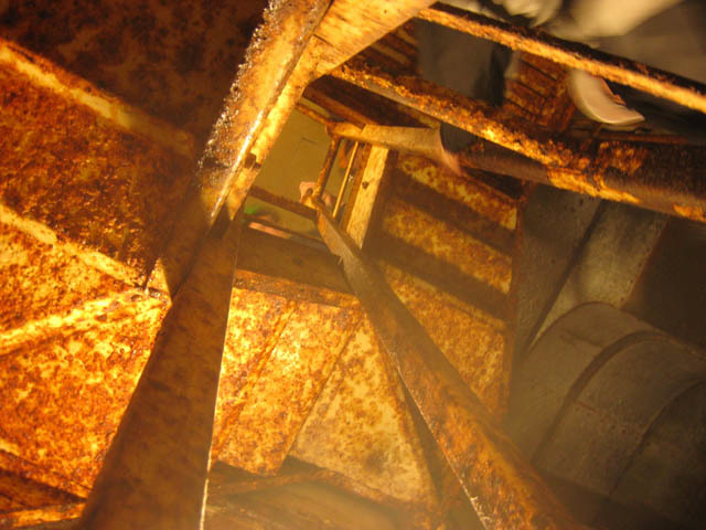 A pair of rusting spiral staircases connect the two floors. 