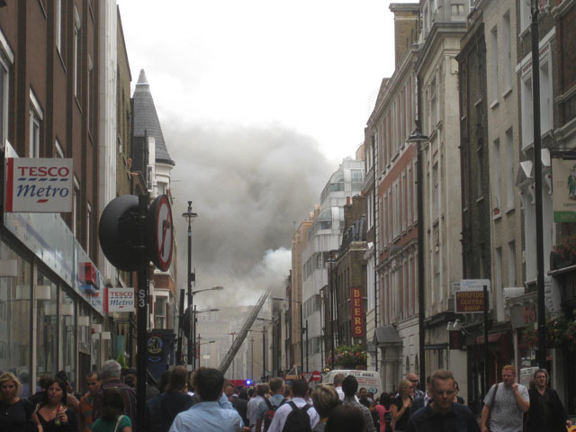 Smoke billows from the upper storey of buildings on Dean Street. 