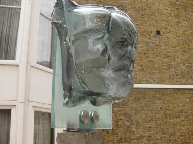 The glassy countenance of Karl Marx stares hard into the lens. 