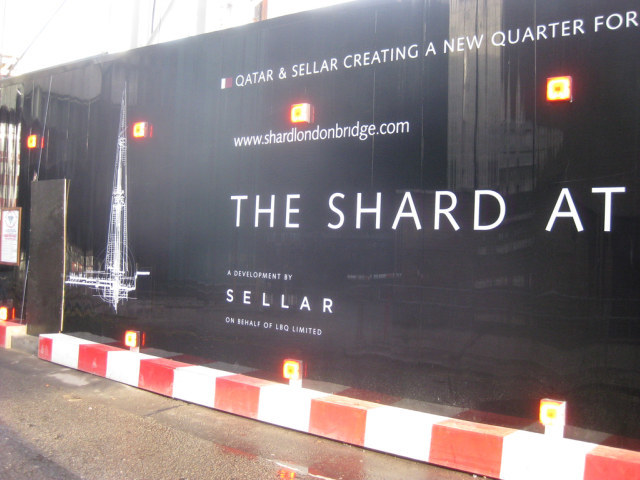 Hoarding surrounding the site. It's possible to see in from a pedestrian bridge stretching along the western side.