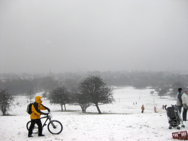 The view from Primrose Hill, whose paths had been salted. To the right of shot, people take turns to sledge down the hill. M@