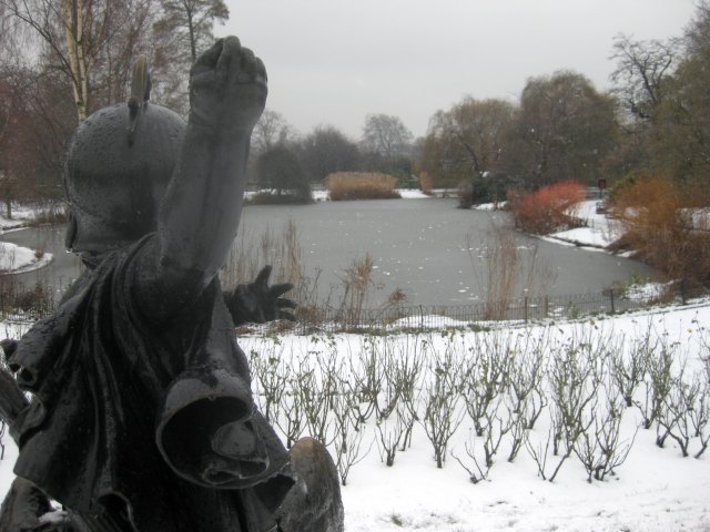 A statue appears to hurl a snowball at a frozen pond in Regent's Park.  M@