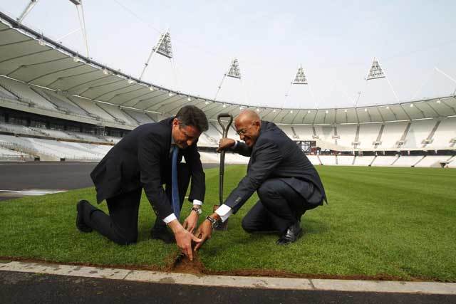 Former Olympian Frankie Fredericks and Seb Coe lay the final piece of turf yesterday. Photo by David Poultney.