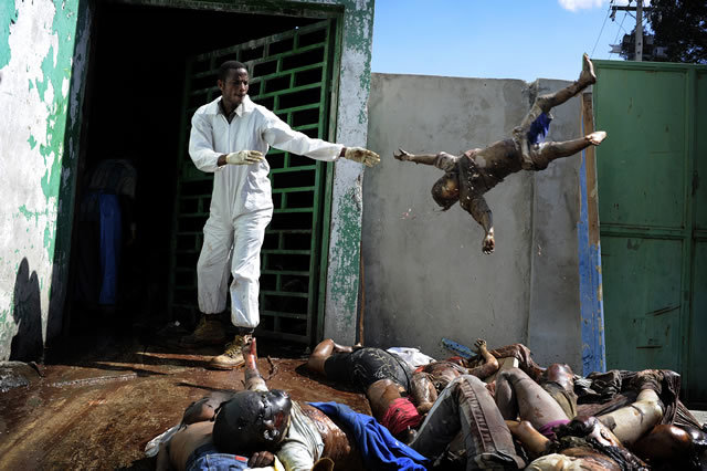 1st Prize General News Stories: Olivier Laban-Mattei, France, Agence France-Presse. Haiti earthquake aftermath, 15-26 January. A man throws a dead body at the morgue of the general hospital, Port-au-Prince, 15 January