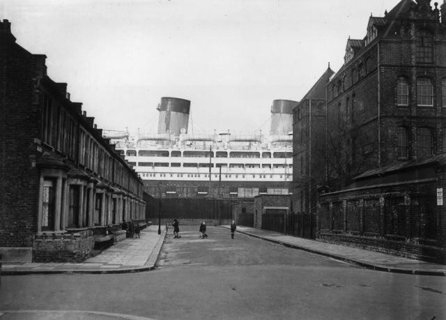 Dominion Monarch: The 26,263 ton Shaw Savill liner Dominion Monarch dwarfs the surrounding houses in Saville Road from her dry dock at the King George V docks in London's Silvertown (Photo by Harry Todd/Getty Images)