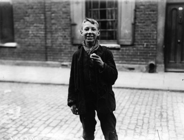 Turnip Eater: 5 July 1912: A young boy makes a meal from a turnip picked up from the road in London's East End. (Photo by Topical Press Agency/Getty Images)