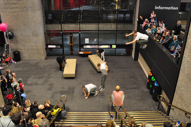 Member of Storm Freerunning leaping off the balcony in the foyer of the Barbican Centre