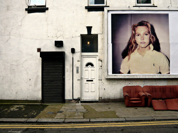 Grimy doorway overshadowed by massive Vampire Weekend ad, by Matthew Gidley