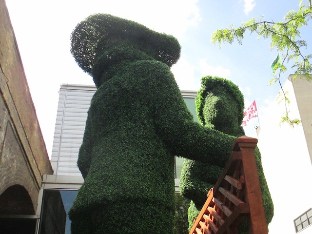 Giant topiary figures bookend the site.