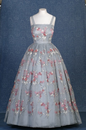 Worn in by The Queen in Nova Scotia during a visit to Canada in 1959, this grey silk organza gown is embroidered with a pink mayflower motif, the provincial flower of Nova Scotia. Royal Collection Trust © Her Majesty Queen Elizabeth II 2013