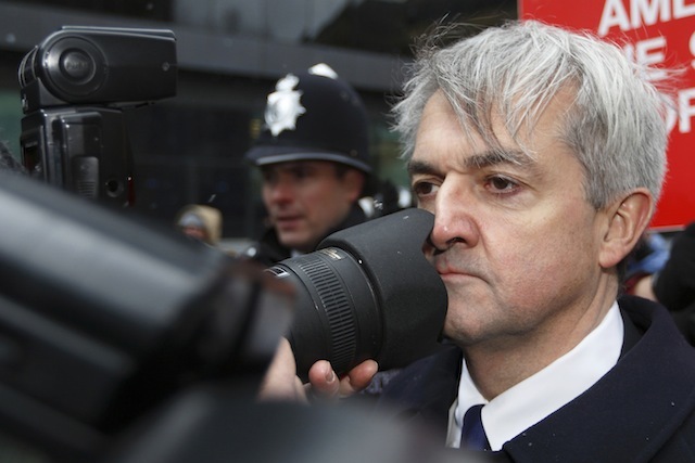 UNITED KINGDOM, London : Former British energy minister Chris Huhne (R) comes into contact with a photographers lens as he arrives at Southwark Crown Court in London, on March 11, 2013. Huhne and his ex-wife Vicky Pryce are due to be sentenced later Monday for perverting the course of justice over speeding points a decade ago. AFP PHOTO / JUSTIN TALLIS