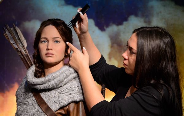 Gemma Sim makes final adjustments to Madame Tussauds newest figure, Katniss Everdeen, protagonist of the worldwide phenomenon The Hunger Games franchise, in its own immersive backdrop.   

Following the release of The Hunger Games: Mockingjay - Part 1, Madame Tussauds has also launched wax likenesses of Katniss, portrayed by Academy Award® winner Jennifer Lawrence, at its New York and Hollywood attractions.

London’s figure portrays Katniss’ in her hunting outfit, which she wears in the second installment of the franchise, The Hunger Games: Catching Fire. Teamed with her iconic brown leather hunting jacket, are dark charcoal trousers, knee-length tie-up leather brown boots, plus brown leather quiver (arrow bag) and trademark bow. Her hair is also styled in her iconic braid.