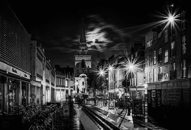 The moon peeks out from behind the clouds at Christ Church in Spitalfields. Photo: Julian Chan