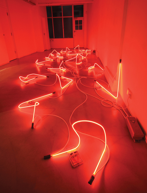 The downstairs gallery glows red with the level of neon on display.