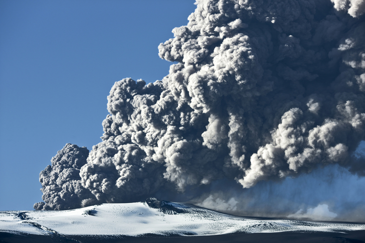 A volcano erupting a cloud of ash