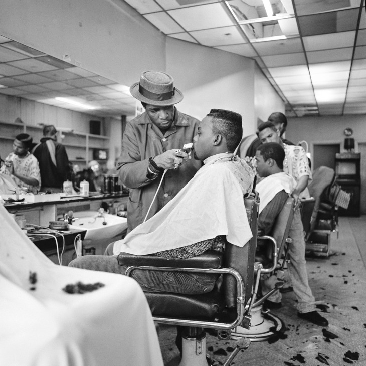 a young man has his hair clipped in a barber shop