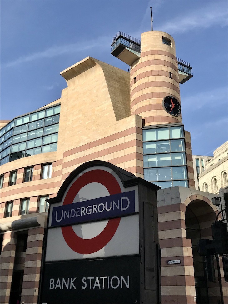 The pink and cream stripy postmodern facade of number One Poultry with a Bank roundel in front