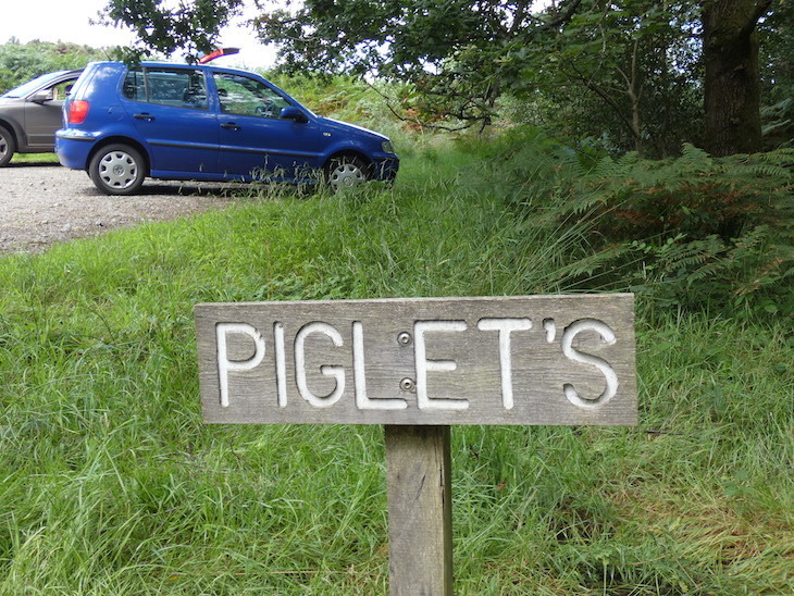 Cars parked in a car park in the Ashdown Forest. A sign reads 