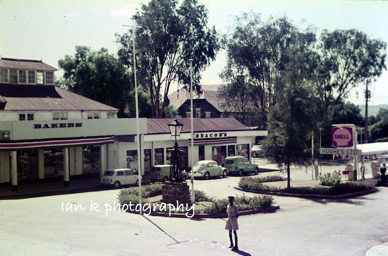 A faded image of a garage in Kenya. At its centre is a lamp post on a granite block.