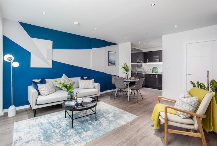 A lounge area with modern furniture and a blue and white flash across one wall.