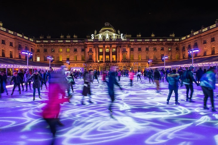 Somerset House courtyard at night with an ice rink in the centre and people skating