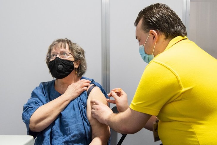a woman gets her covid jab at the science museum