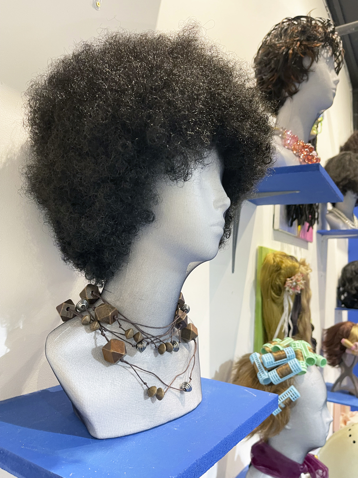 an afro wig on a bust, with others behind it