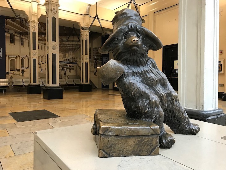 A statue of Paddington sitting on his case in Paddington Station