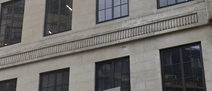 A long row of sculpted candles on the side of a portland stone building