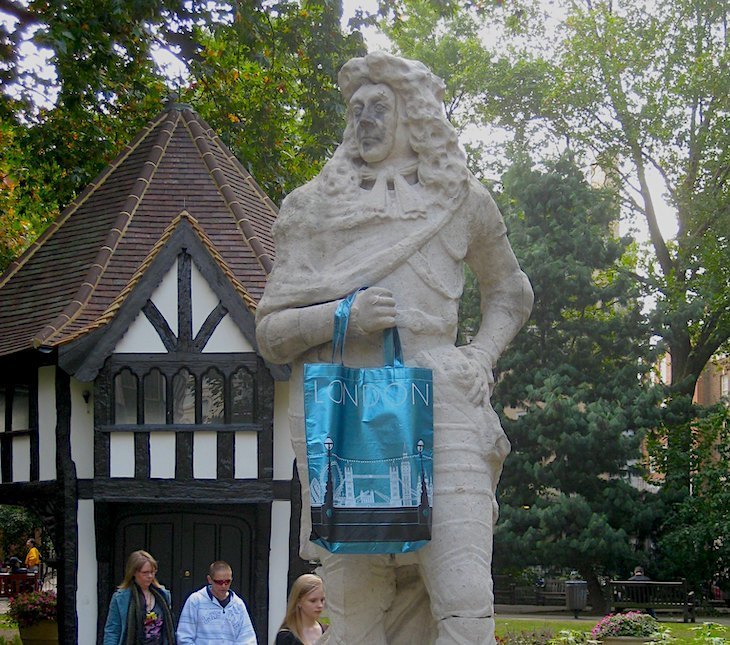 Charles II statue clutching a blue handbag. A mock Tudor shed is in the background.