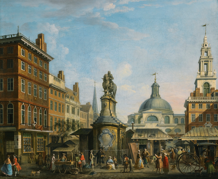 A colour image of an equestrian statue in the middle of a city scape.