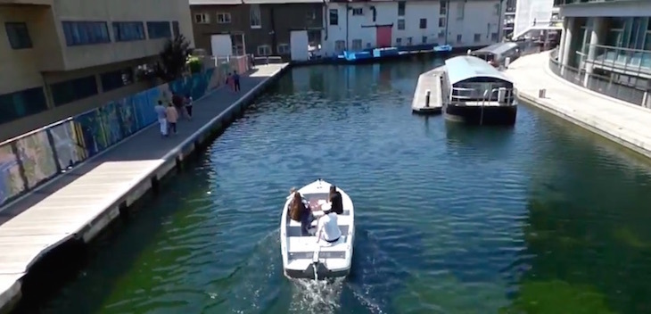 Looking down from a footbridge onto a motor boat on the canal at Paddington
