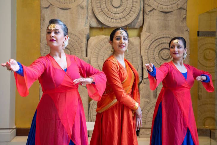 Three women in traditional Indian dance costumes