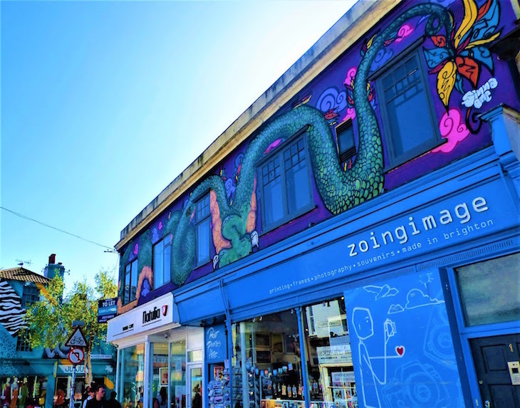 A shopfront in The Lanes. The whole building is painted blue, with a large snake mural above the shop.