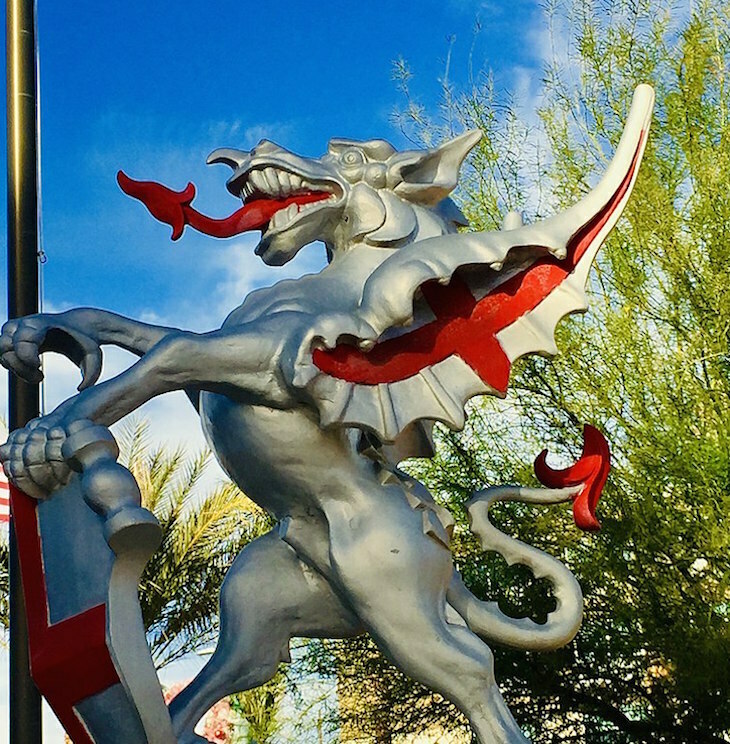 A silver dragon statue with red bits under the wings