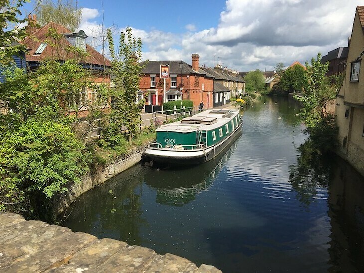 Canal viewed from a bridge. A pub is on the left, middle-distance