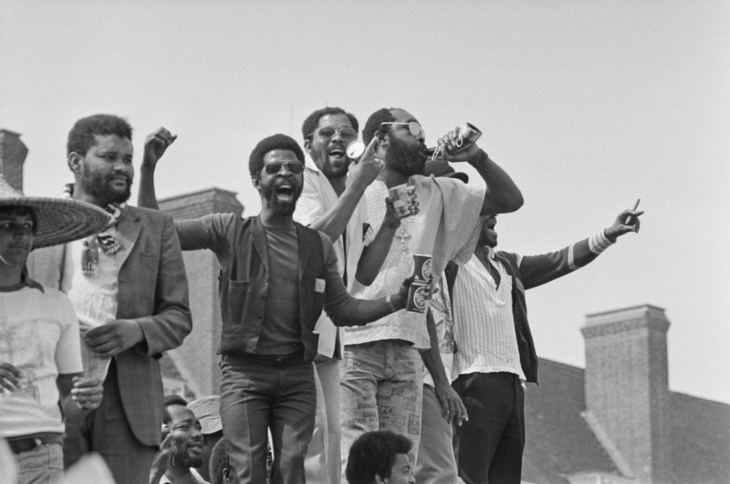 Men stand up and celebrate by cheering and drinking beer