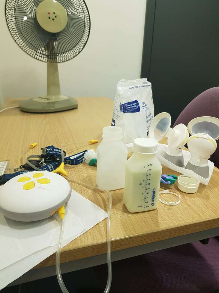 A breastpump can be seen on a table. It has been taken apart ready to pack away and a 250ml bottle is full of breastmilk. 