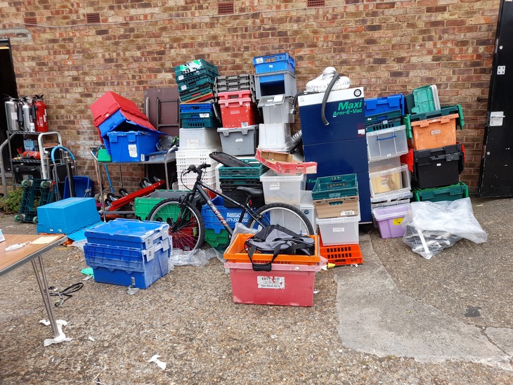 A heap of boxes, a bike and an old air conditioning unit