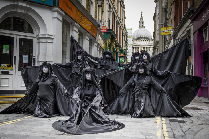 People dressed in black cloaks posing in front of St Paul's