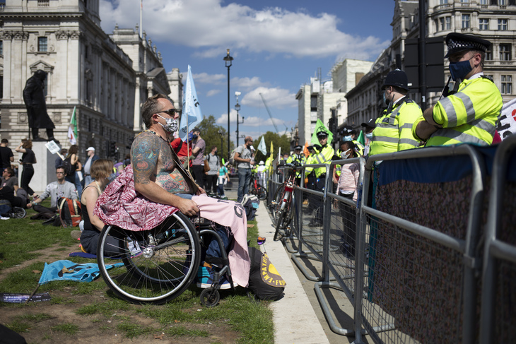 A tattooed man in a wheelchair faces off with police