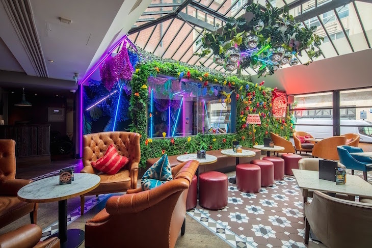 The interior of 100 Wardour street, decorated with tropical fake flowers and plants