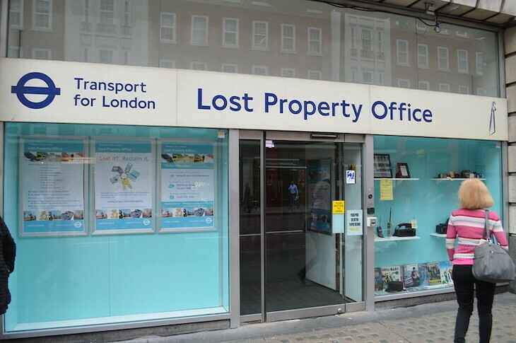 The turquoise Lost Property Office of tfl. A lady in pink stands to the right