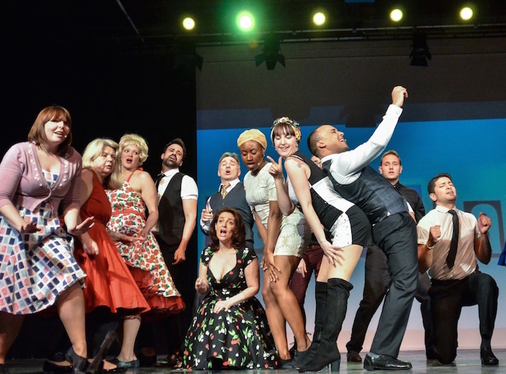 A group of performers on stage, singing together