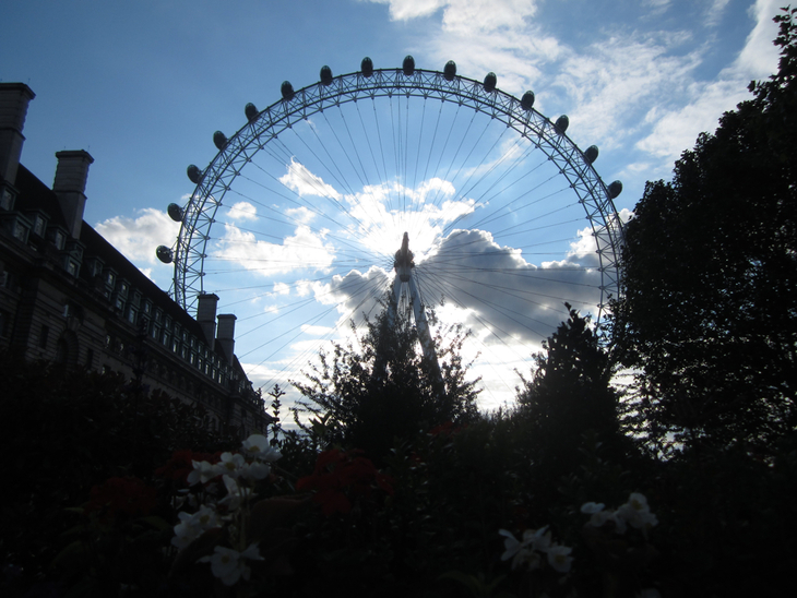 The London Eye silhouetted against a cloudy blue sky