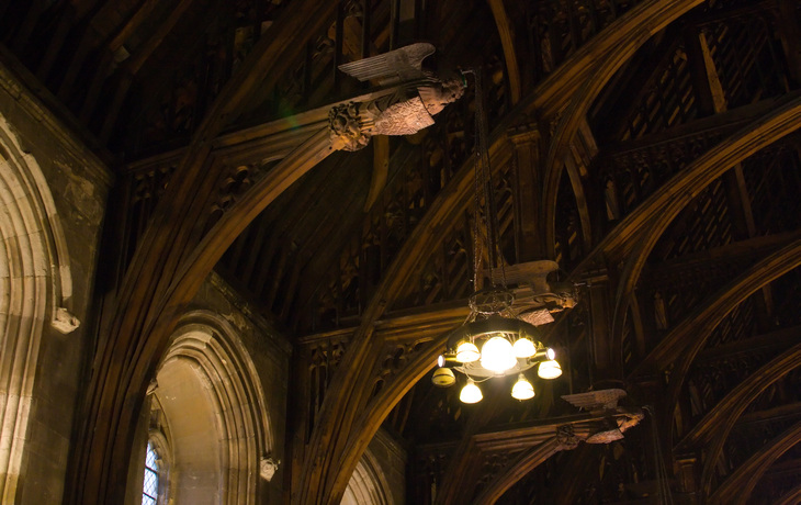 A carved angel looks down from the wooden rafters