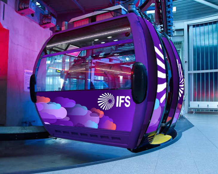 A mock-up of an IFS branded cable car gondola in one of the terminals. It's mainly purpole, with lilac, blue and red clouds acrss the front, and the IFS logo in white.
