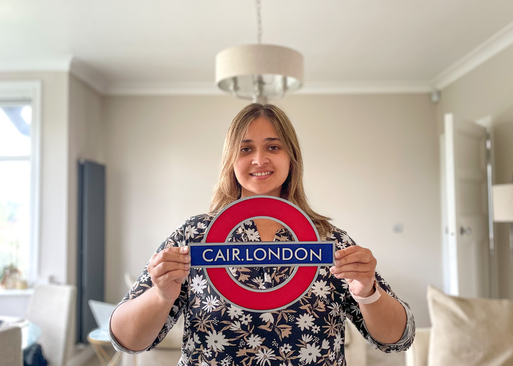 Beri holding a roundel with Cair London written on it