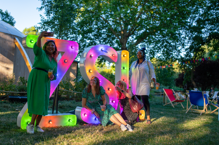 Things to do this week in London: a group of four women posing for a selfie in front of a large illuminated 'ZSL' sign at Zoo Nights