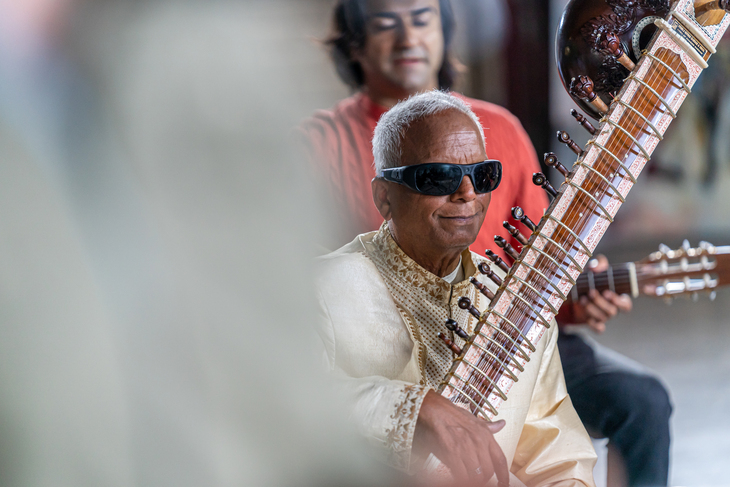 A man in sunglasses with a sitar